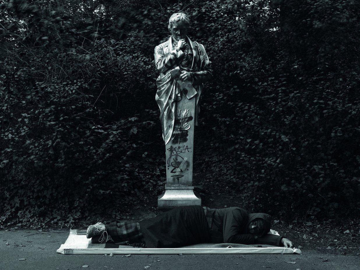 Das Bild zeigt den K&uuml;nstler Simon Wachsmuth w&auml;hrend einer Schlafperformance vor dem Heinrich von Kleist-Denkmal im Viktoria.